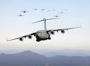 A formation of military cargo aircraft flying over a mountainous landscape, showcasing aviation power.